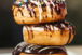 three chocolate-coated donuts with sprinkles